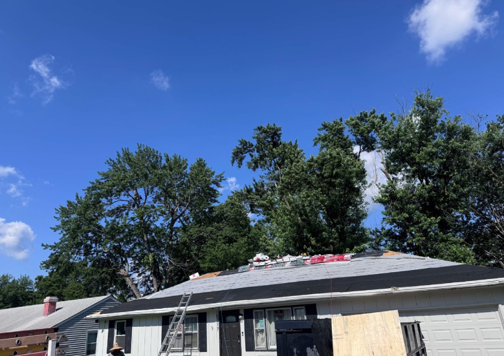 Mid-job: synthetic underlayment down, new bundles staged on the ridge